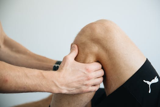 Home Detailed image of a physiotherapy session focusing on knee massage treatment.