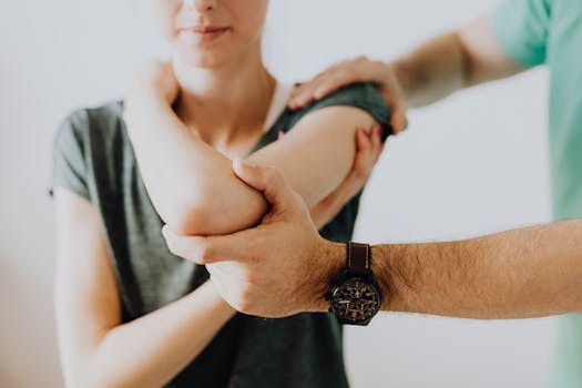 A chiropractor adjusting a patient's arm in a clinic setting, focusing on health and care.